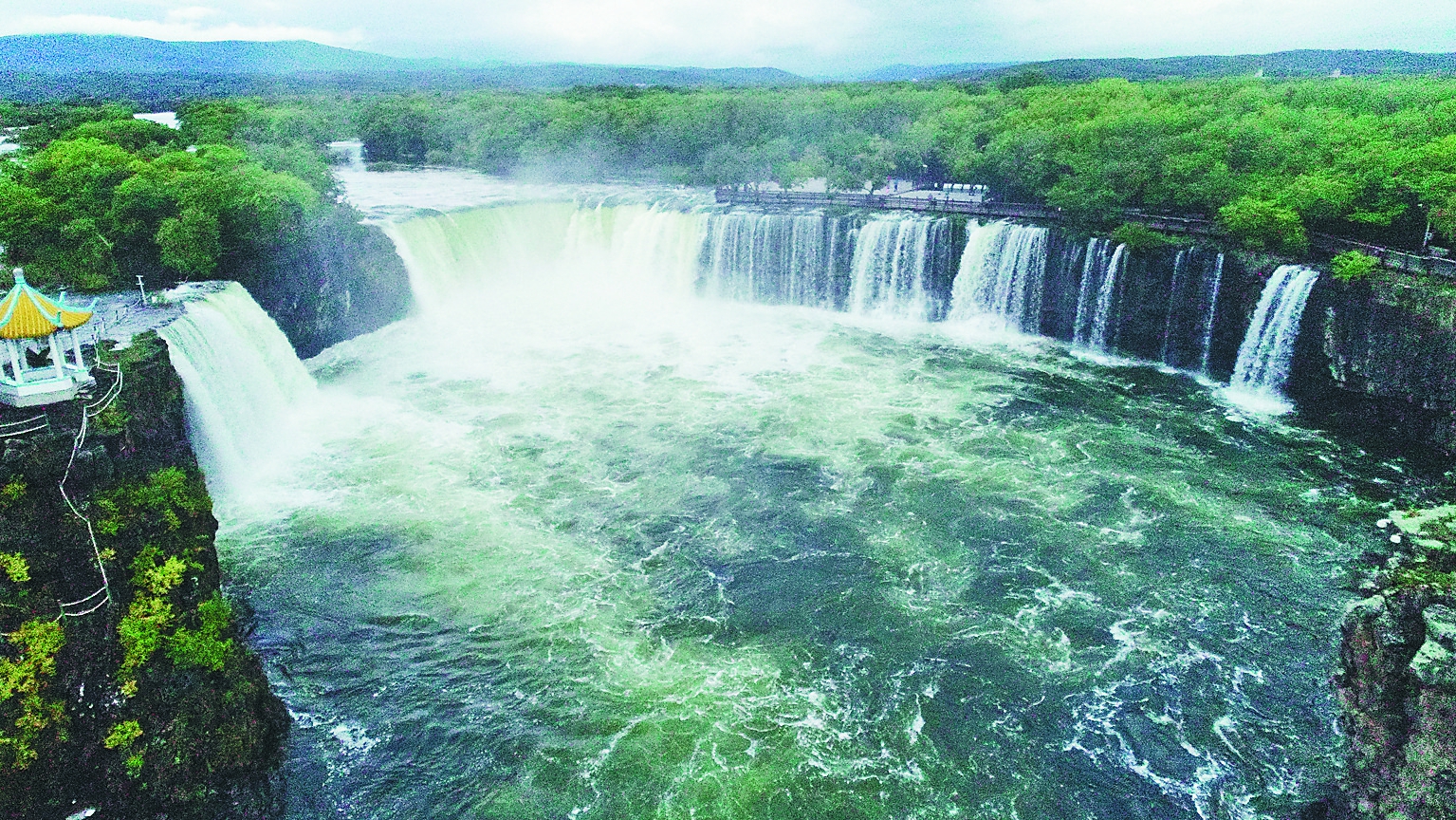 世界地质公园镜泊湖景区吊水楼瀑布出现大范围溢流,形成上百米宽